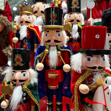 Colorful wooden nutcracker soldiers arranged in a festive display, featuring traditional Christmas decorations, bright uniforms, and classic holiday craftsmanship