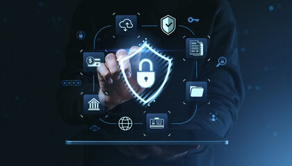 Cybersecurity data protection concept with lock icon hologram and digital interface above tablet on dark background representing secure technology systems.