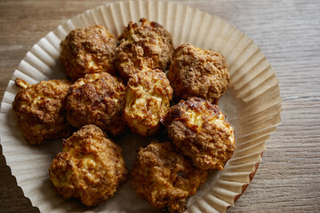 Homemade cheese balls placed in a paper tray ready for serving at a small gathering in the kitchen during the afternoon