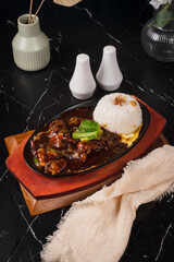 Delicious Sizzling Steak with Rice on a Hot Plate.
