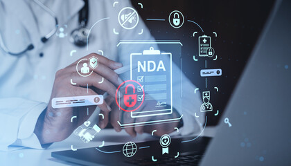 Doctor using digital tablet with holographic NDA and medical security icons concept on futuristic technology background in healthcare setting.