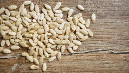 Collection of white seeds on a wooden surface scattered during midday