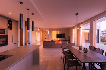  Modern, bright living room featuring a comfortable sofa and panoramic glass doors opening to a stunning private swimming pool and lush garden. Perfect for luxurious indoor-outdoor living