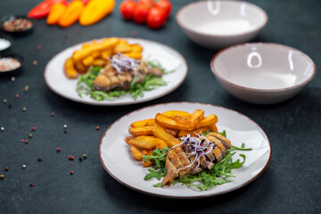Duck breast with fries and arugula served on plates
