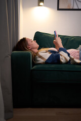 Emotional exhaustion on sofa after day of screens and messages