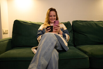 Evening digital relaxation with woman smiling at smartphone