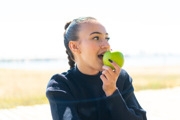 Young moroccan girl  at outdoors holding an apple