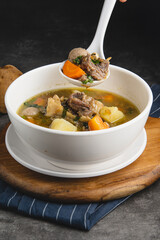 Hearty Beef and Vegetable Soup in White Bowl.