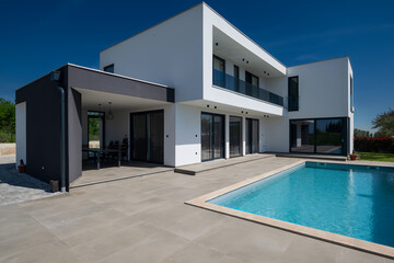 Modern luxury villa with swimming pool and clean minimalist architecture under a blue sky....
