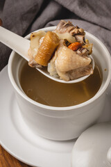 Nourishing Chicken Soup with Herbs in a White Bowl.