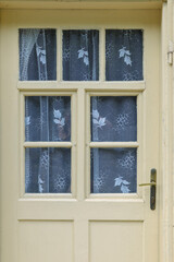 Wooden door with patterned lace curtains in Spania Dolina
