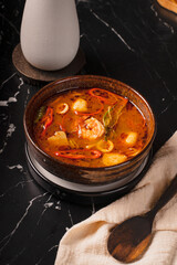 Spicy Seafood Soup with Shrimp and Squid in a Dark Bowl.