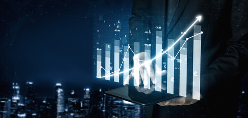 A professional businessman analyzes financial data displayed on a tablet, showcasing upward trends and growth. The urban backdrop enhances the modern tone. Impute
