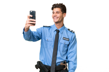 Young police man over isolated background making a selfie