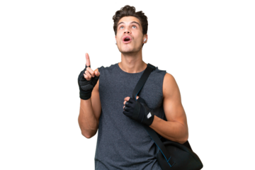 Young sport caucasian man with sport bag over over isolated background pointing up and surprised