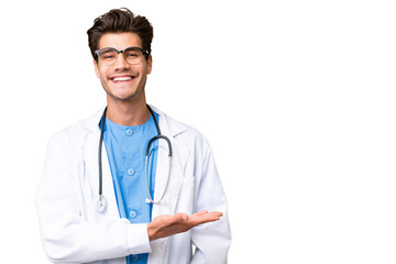 Young doctor man over isolated background presenting an idea while looking smiling towards