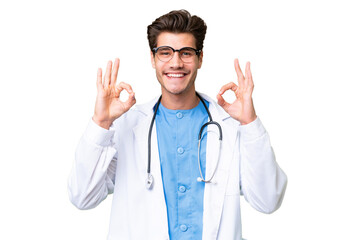 Young doctor man over isolated background showing an ok sign with fingers