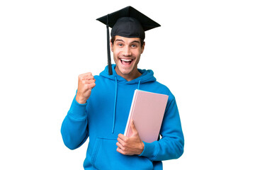 Young university graduate man over isolated background celebrating a victory in winner position