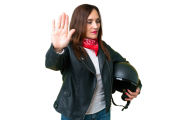Middle age caucasian woman with a motorcycle helmet over isolated chroma key background making stop gesture and disappointed