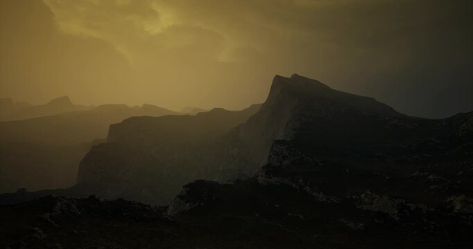 Silhouetted mountains rise against a hazy sky tinged with orange and gray. The dramatic landscape evokes a sense of mystery and adventure during twilight hours.