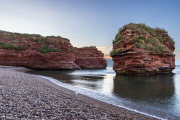 A sandstone sea stack at Ladram Bay near Sidmouth in South East Devon, captured at sunrise in July.	
