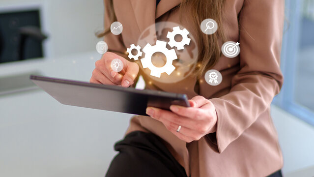 Adult professional woman operating digital tablet planning business strategy optimizing processes implementing solutions modern office environment - Powered by Adobe