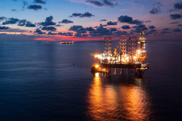 Aerial view of offshore jack up rig and offshore platform during sunset for oil and gas exploration...
