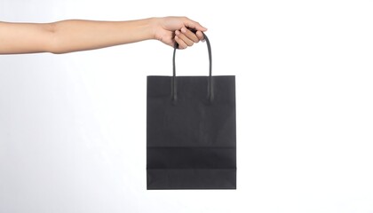 Arm holds a sleek, rectangular black paper bag with handle against a white background in clean studio lighting