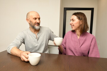 Couple enjoys coffee together in a cozy kitchen during a morning chat