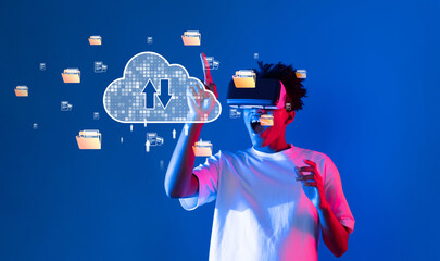 A young man interacts with advanced technology using a virtual reality headset. Cloud computing graphics highlight online storage systems in a vibrant digital setting. XDMCP