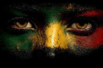 Naklejka premium front view artwork painted of a person face in the colors of a virtual rastafarian flag on black background, created by a digital artist to express cultural identity, symbolic color meaning.