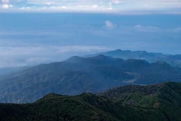 Obraz premium A breathtaking panoramic view of a lush green mountain range stretching into the misty horizon
