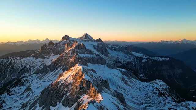 Stunning aerial view of the majestic snow-capped mountain range at sunrise showcasing natural beauty