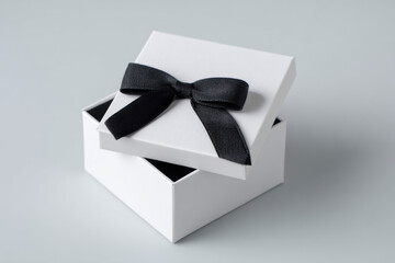 A gift box with a ribbon sits open on a light surface