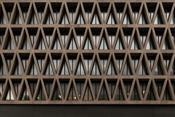 Modern building facade with shaped geometric structure and glass windows.