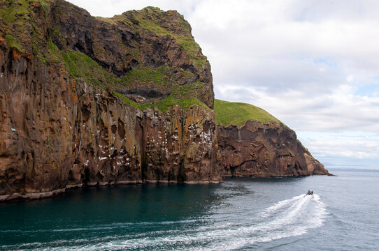 Vestmannaeyjar Iceland, view of cliffs from ocean with boat on water