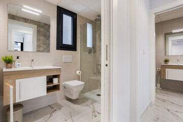 Modern bathroom with floating vanity, glass shower and marble tile flooring