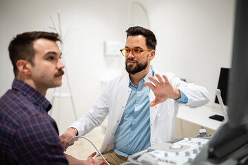 Obraz premium Doctor performing ultrasound examination on male patient arm