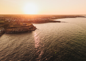 Tynemouth UK: 16th Aug 2025: Golden hour over Tynemouth showcasing the coast and Tynemouth Priory drone view from out to the sea
