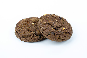 Chocolate cookies isolated on white background. Two round cookies with visible pieces, sweet dessert, bakery product, snack food concept and minimal studio shot.