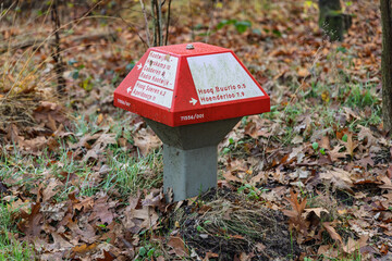Traditional Dutch concrete mushroom-shaped directional sign (paddenstoel) in the forest showing cycling and walking routes near Kootwijk.