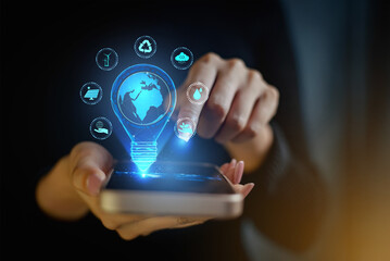 Green technology light bulb with environmental icons on smartphone