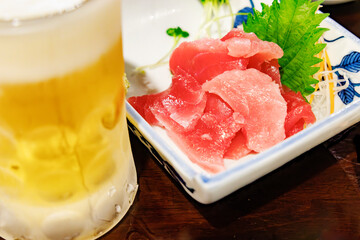 居酒屋で楽しむ生ビールと新鮮なマグロの刺身