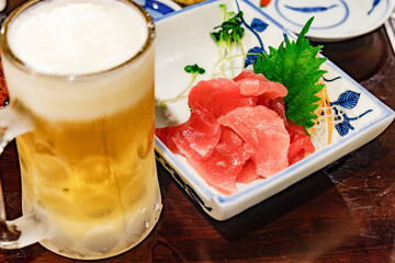 居酒屋で楽しむ生ビールと新鮮なマグロの刺身