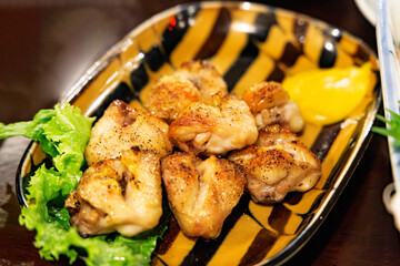 香ばしく焼き上げられた手羽先（鶏肉）とレモンのクローズアップ