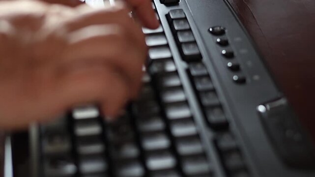 Un primer plano de las manos de una mujer adulta en movimiento en un teclado de una computadora con un poco de desenfoque