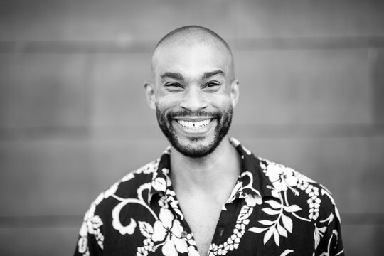 Black and white smiling portrait of a young male with floral shirt