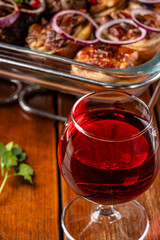 Red wine glass with rustic meat dish