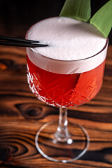 Red cocktail with foam in crystal glass