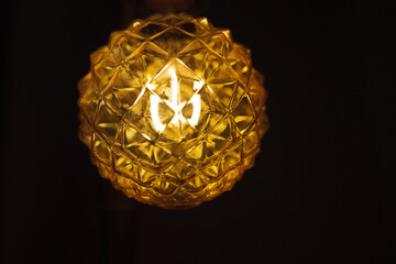 an old spherical relief lamp shines on a dark background